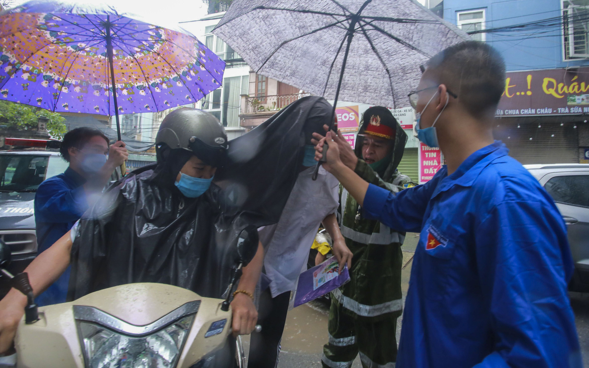 Thi vào lớp 10: Mưa như trút, tình nguyện viên đội mưa che ô, cõng sĩ tử vào phòng thi