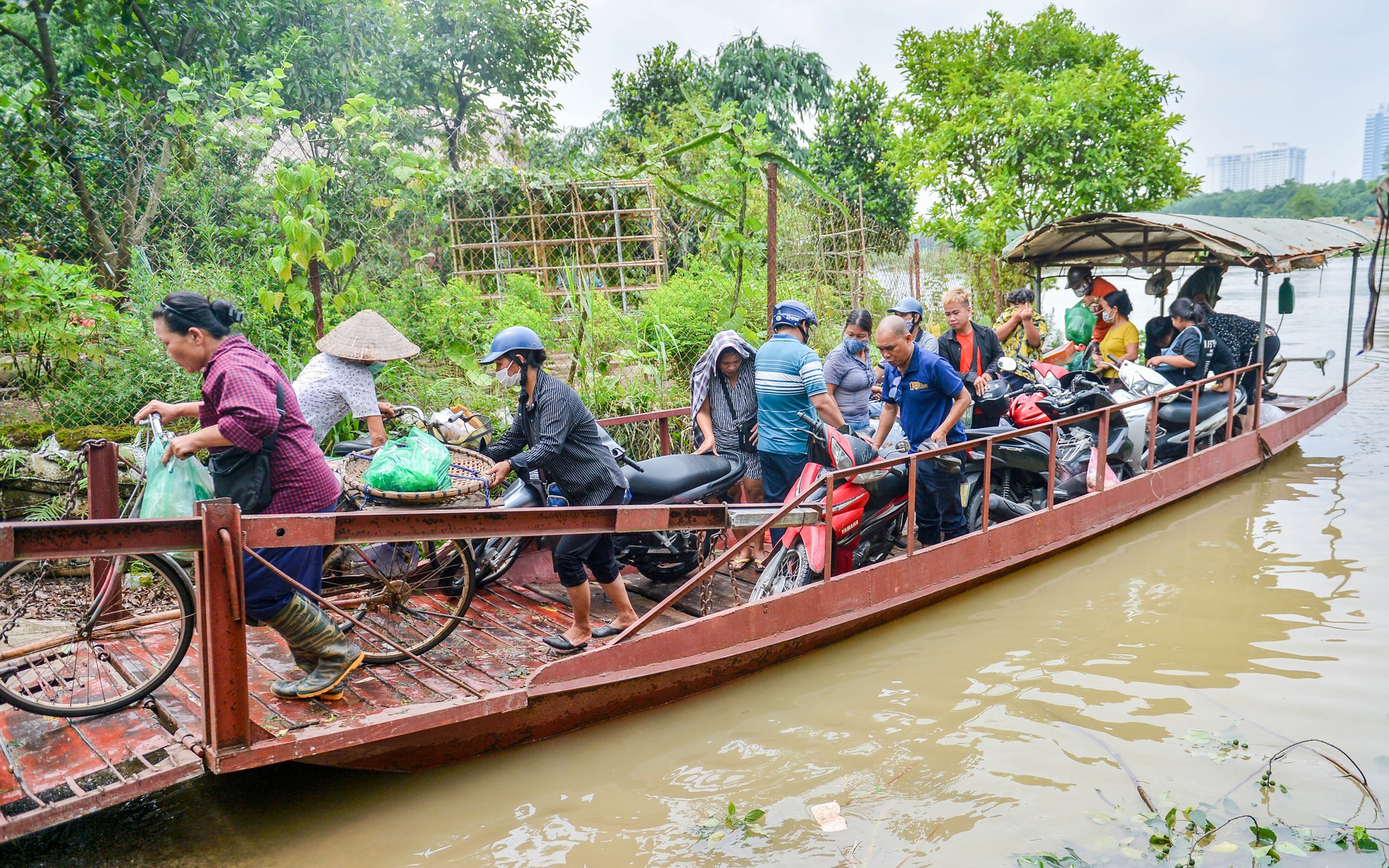 Nước sông Hồng dâng cao, nhiều hộ dân mắc kẹt phải đi đò qua đoạn đường ngập sâu 2m